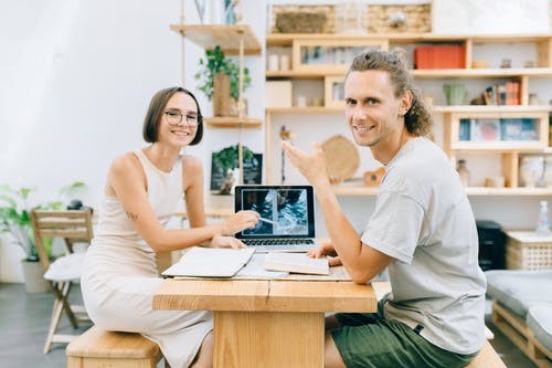 Man and Woman Sitting on Chair Using Laptop Computer