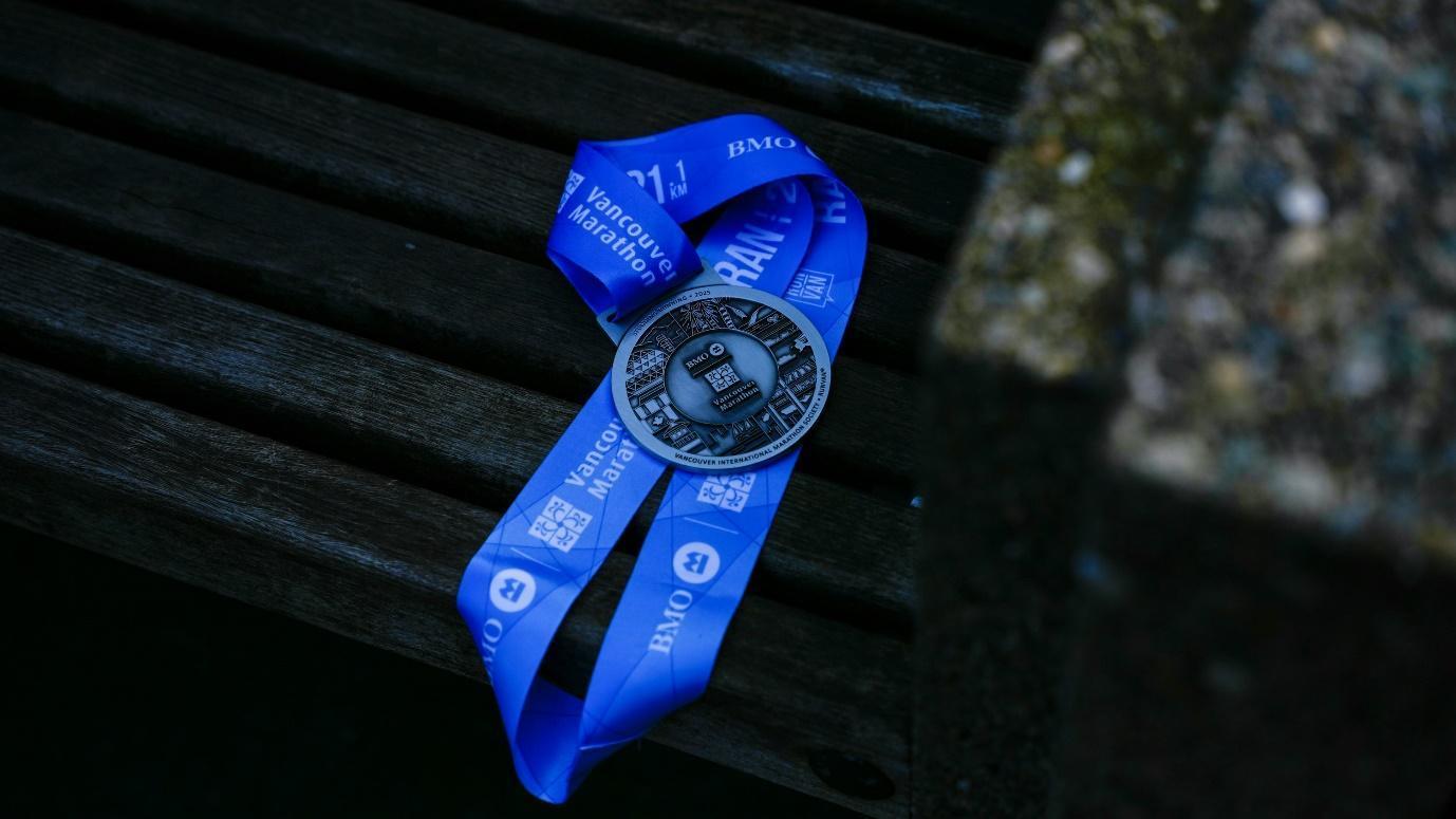 A blue ribbon medal lies on a wooden bench.